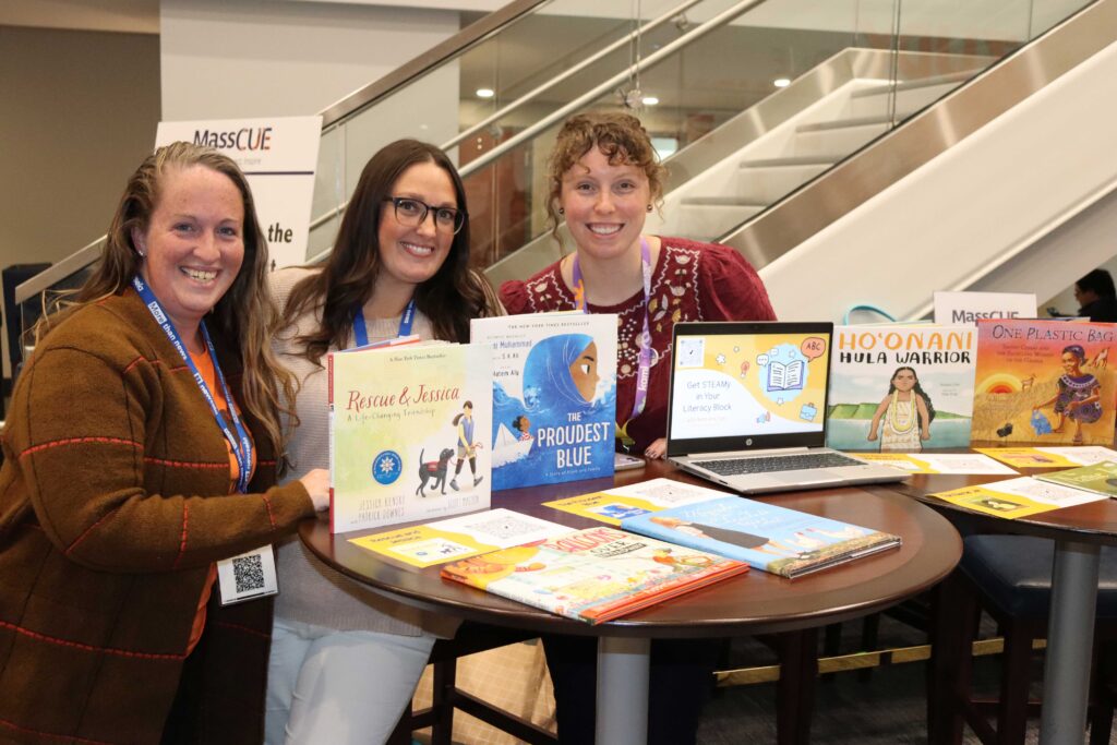 Three educators pose with books in the Educator Showcase